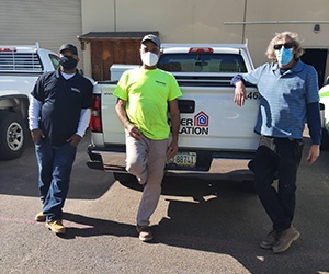 Three male Banker Insulation employees standing in front of a pickup truck.