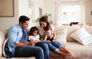 A happy family sitting together on a cozy couch in their well-insulated home, enjoying a comfortable indoor environment.