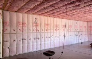 A close-up of fiberglass insulation being installed, highlighting its affordability and long-term energy-saving benefits for homeowners in the Southwest.