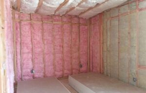 Fiberglass insulation installed in a home theater wall, demonstrating its sound-dampening properties and contribution to a quieter, more comfortable living space.