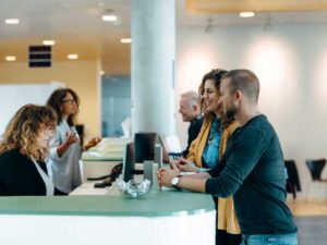 Customers at a bank speaking with the teller.