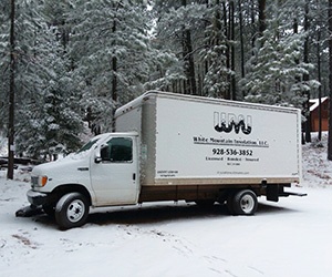 White Mountain Insulation truck in a snowy woods in Snowflake, Arizona.